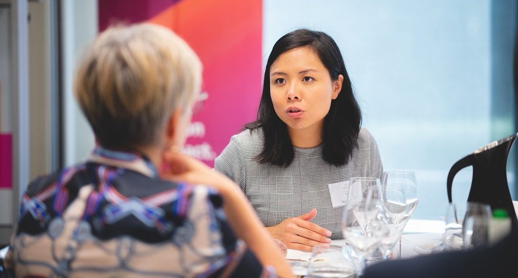 Entrepreneurs talk at a table in PwC Canberra