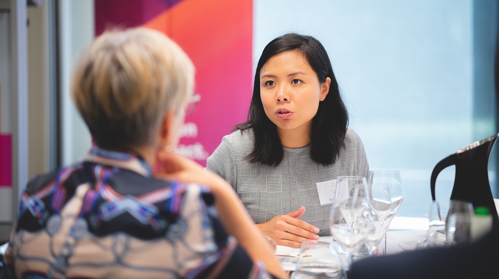 Entrepreneurs talk at a table in PwC Canberra